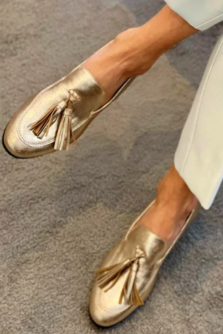 mocassini oro metallizzati con nappine e cuciture decorative.