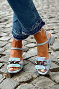 tacchi bassi blu con catena metallica e cuciture decorative.