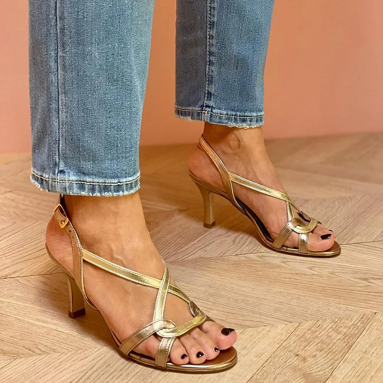tacchi stiletto comodi in pelle sintetica lucida con punta aperta e cinturini incrociati.
